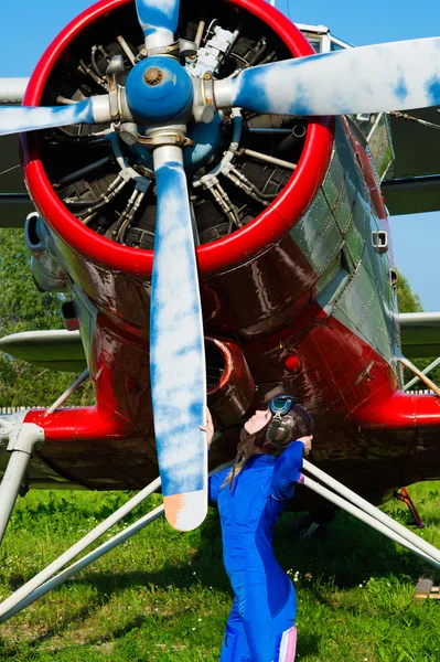 Kobieta pilot w kasku stojący przy śmigle samolotu — Zdjęcie stockowe