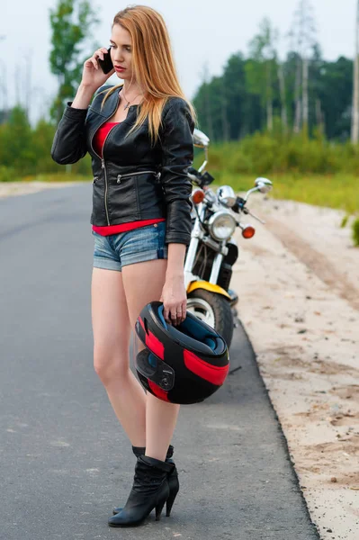 Jonge vrouw Biker praten op een mobiele telefoon terwijl een motorhelm — Stockfoto