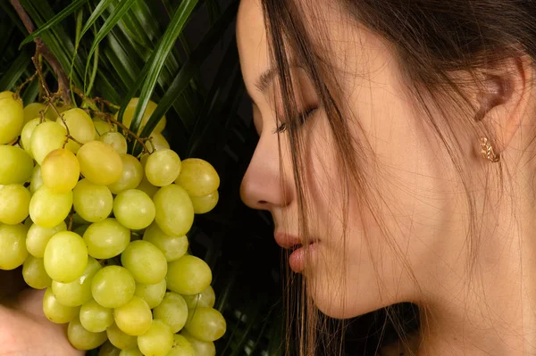 Menina morena atraente segurando uvas — Fotografia de Stock