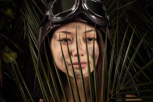 Porträtt av vacker flicka med ansiktet smutsiga med ett tropiska löv — Stockfoto