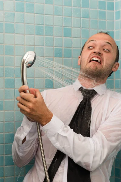 Obchodní muž bojuje se sprchou v koupelně — Stock fotografie