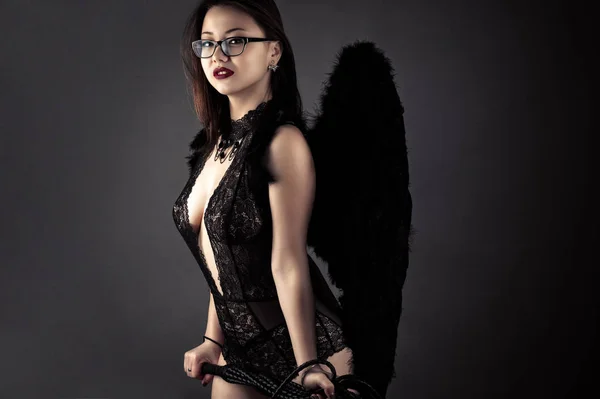 Sexy coreano menina com chicote em mãos com preto asas — Fotografia de Stock