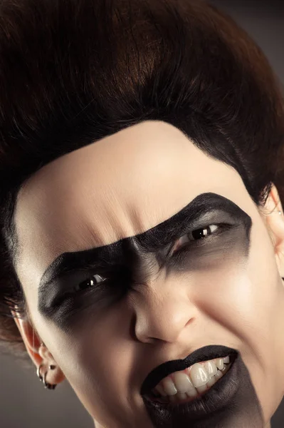 Агрессивное лицо женщины с творческим темным макияжем — стоковое фото