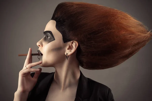 Hermosa mujer con pelo exuberante con cigarrillo en la boca —  Fotos de Stock