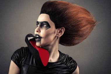 bir koyu makyaj ve topuk içinde ağız ile gür saç modeli ile büyüleyici kadın