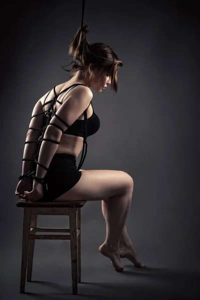 漂亮的女奴隶，坐束缚的绳索在椅子上 — 图库照片
