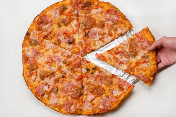 Рука берет кусок пиццы — стоковое фото