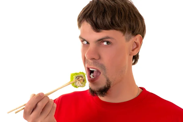 Bonito homem emocionalmente comer sushi roll — Fotografia de Stock