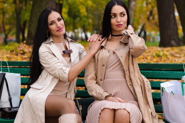 Twee vriendinnen zitten op bankje met winkelen — Stockfoto