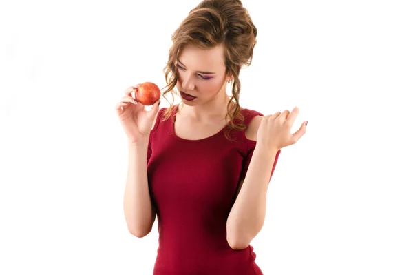 Charming teenager girl in red dress with nectarine in hand — Stock Photo, Image