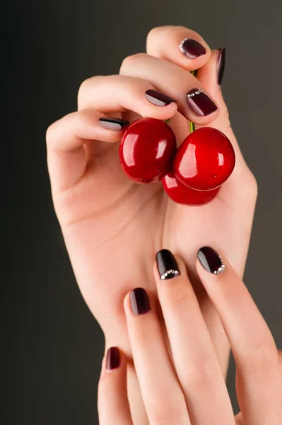 Fashion manicure female hand with cherry — Stock Photo, Image
