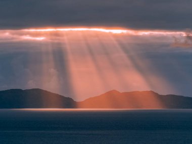 Görkemli günbatımı üzerinde Outer Hebrides, Neist noktası cliff üzerinde Isle of Skye, İskoçya'dan görüldüğü gibi. Karanlık Bulutların arasından ışık saçan ışık ışınlarının kadar yakın ve derin mavi denizde Parlatıcı.