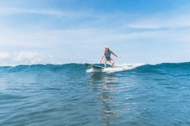 Yüzme takımı ve okyanusta sörf kap içinde kadın