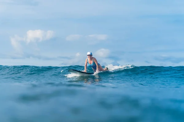 Séduisante femme couchée sur planche de surf dans l'océan — Photo de stock