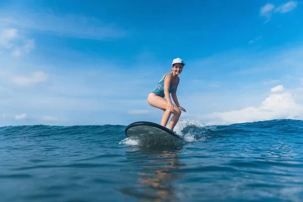 Приваблива усміхнена жінка в купальнику, серфінг в океані — стокове фото