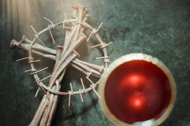 Holy communion on wooden table on church.Taking Communion.Cup of glass with red wine, bread and Holy Bible and Cross on wooden table.The Feast of Corpus Christi Concept. clipart