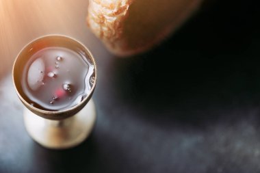 Kilisede tahta masa üzerinde kutsal komünyon. Kırmızı şarap, ekmek ile cam kutsal Komünyon.Cup alarak. Corpus Christi Kavramı Bayramı.
