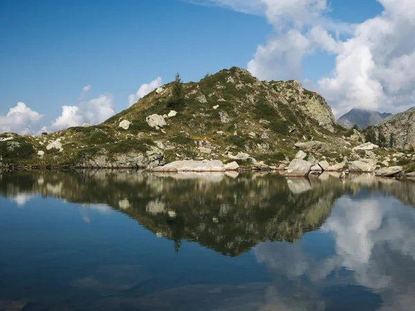 Las montañas reflexionan sobre un pequeño lago alpino en los Alpes bergamascos —  Fotos de Stock