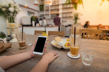 Kafede telefon kullanan kadın.