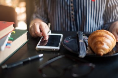 Kafede telefon kullanan kadın.