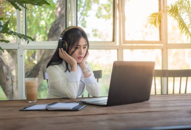 Kafede dizüstü bilgisayar ile çalışan genç Asyalı kadın