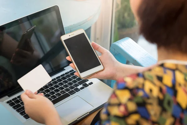 Cep telefonu ve kredi kartı tutan kadın