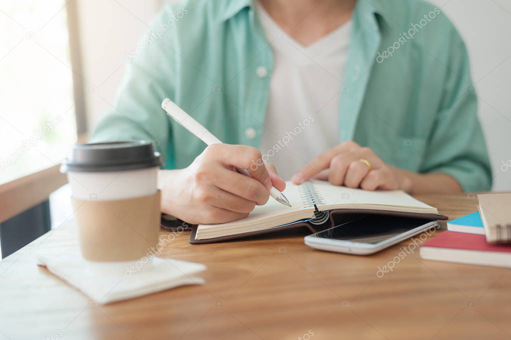Asian man writing text on notebook