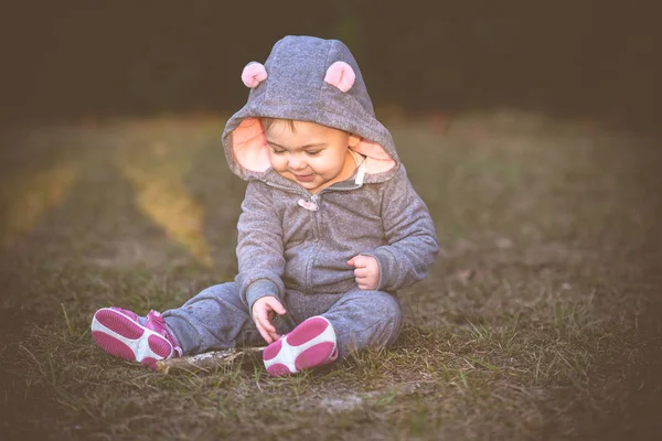 Baby in a super cute mouse, animal costume, happy one year old girl. Baby loves outdoors and parks