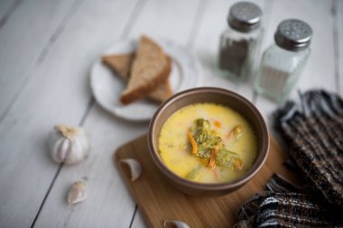 Brokoli peyniri çorbası, kızarmış ekmekle servis edilir.