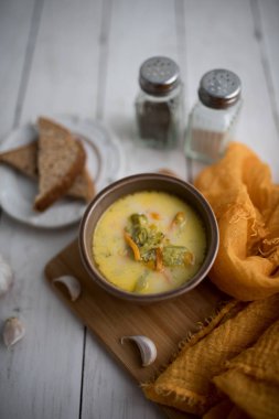 Brokoli peyniri çorbası, kızarmış ekmekle servis edilir.
