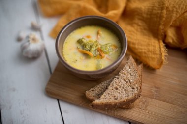 Brokoli peyniri çorbası, kızarmış ekmekle servis edilir.