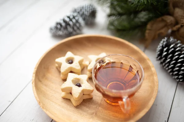 Christmas shortbread star cookies with strawberry jam. Festive atmosphere holiday pastry baking concept. Cookies and tea for Santa