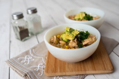 Lezzetli fasulye, taze tavuk ve yavaş pişirilen, ekşi krema ve avacado ile süslenmiş zengin ve kremalı et suyu.