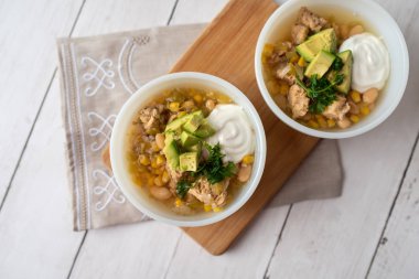 Lezzetli fasulye, taze tavuk ve yavaş pişirilen, ekşi krema ve avacado ile süslenmiş zengin ve kremalı et suyu.