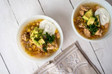 Lezzetli fasulye, taze tavuk ve yavaş pişirilen, ekşi krema ve avacado ile süslenmiş zengin ve kremalı et suyu.