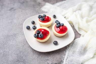 Kirazlı ve yaban mersinli mini peynirli kekler, tatlı yaz ziyafeti.