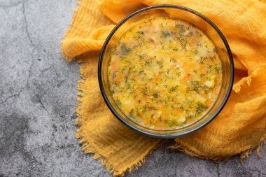 Çorba kulesh darı, patates ve havuç turuncu bir bez üzerinde berrak bir kase içinde. Kulesh Yoğun Ukrayna geleneksel çorbası.