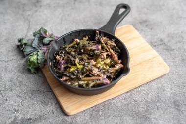 Kızarmış kalette, tereyağında pişmiş ve dökme demir tavada sarımsak..