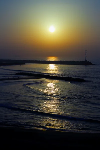 O farol no cais ao pôr-do-sol no Mar Mediterrâneo — Fotografia de Stock