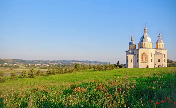 Holy temple on a hill with poppies against a clear sky. — Stock Photo, Image