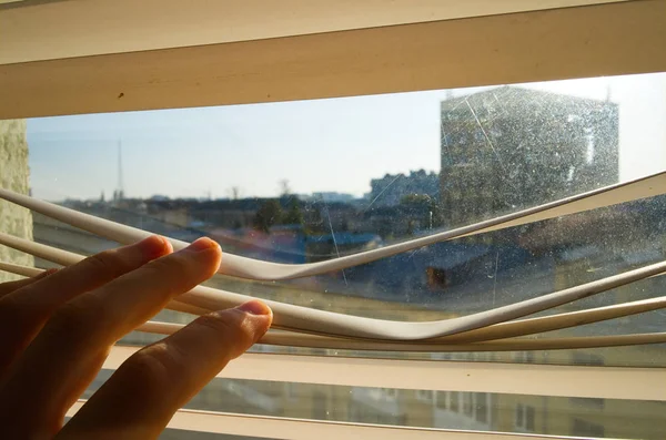 Mladý Muž Dívá Plastikovými Okny Ulici Zavřít Ruku Otevřít Jalousie — Stock fotografie