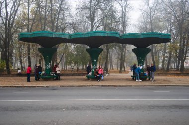 Ivano-Frankivsk, Ukrayna - Ekim 2019: İnsanlar otobüs durağında otobüs bekliyor. Sonbahar sabahında soğuk sisli hava.