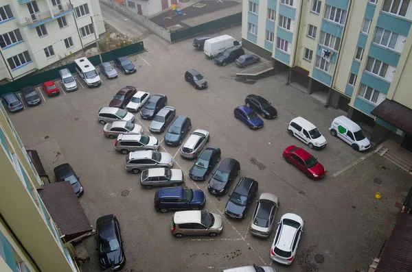 Ivano-Frankivsk, Ukrayna - Ekim 2019: Yüksek konutlu binaların çevrili olduğu açık otoparkın havadan görünüşü. Park etmiş arabaların olduğu avlu, çok katlı binanın üst katının manzarası..