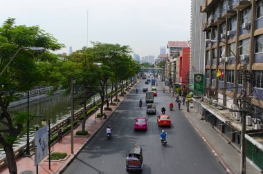 Bangkok, Tayland, Aralık 2015: Bangkok Kanal Nehri (Khlong) ve yeşil ağaçlar boyunca şehir trafiği yolu. Görünüm formu köprüsünün üstünde.