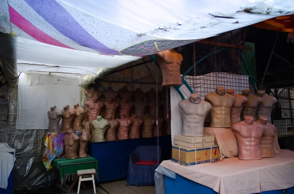 Rows of male body mannequins in empty street store. Plastic dummy bodies in street market shop. Ukraine.