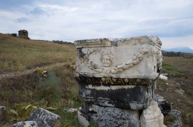 Hierapolis antik Yunan şehrinin kalıntıları Pamukkale kaplıcalarında yer alıyor. Yüzü olan harap bir taş sütun. Türkiye.