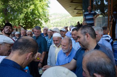 Karahayit, Türkiye - Eylül 2018: Satıcının bir bardağa limon suyu sıkmasını izleyen bir kalabalık. Sokaklarda satmak için meyve suyu sıkacağı. Sadece gerçek insanlar şehirde toplanır.,