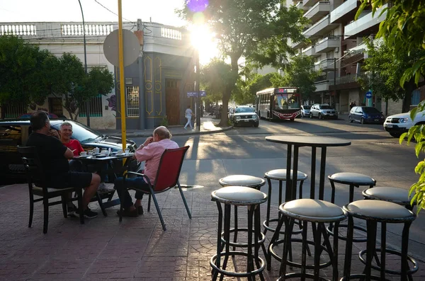 Cordoba, Arjantin - Ocak 2020: Üç adam gün batımında caddenin dışındaki kafede kahve içiyor..