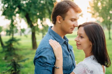 Genç kalma ve parkta sunset bulvarında flört çift. Mutlu bir adam ve güzel kadın dışarıda eğleniyor.