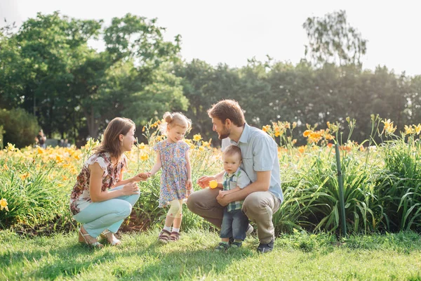 Joven Familia Feliz Divirtiéndose Flores Aire Libre Pareja Enamorada Sosteniendo — Foto de Stock
